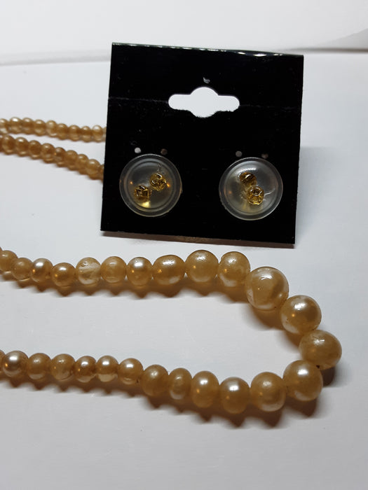 Golden faux pearl necklace and button earrings